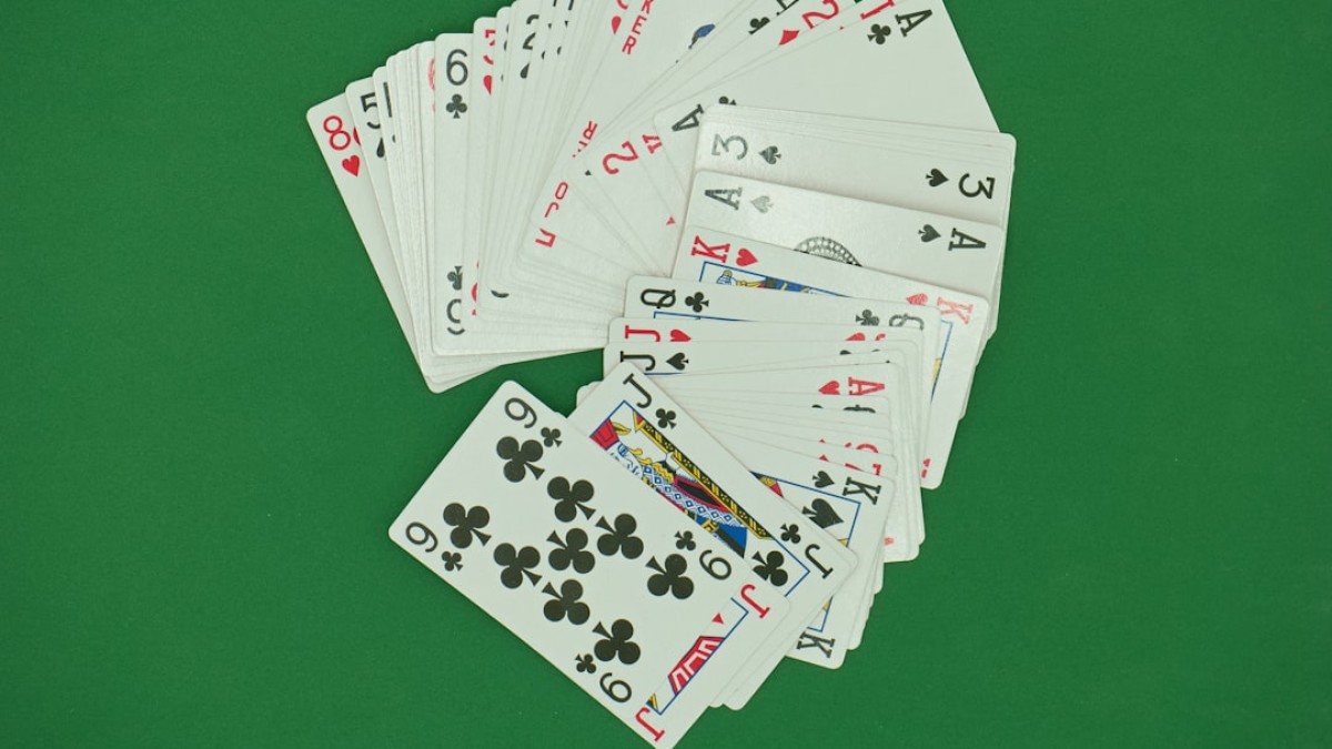 a pile of playing cards sitting on top of a green table