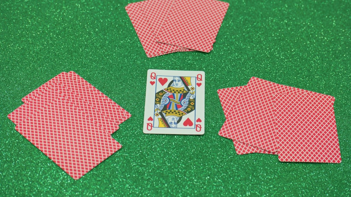 a set of four playing cards sitting on top of a green table