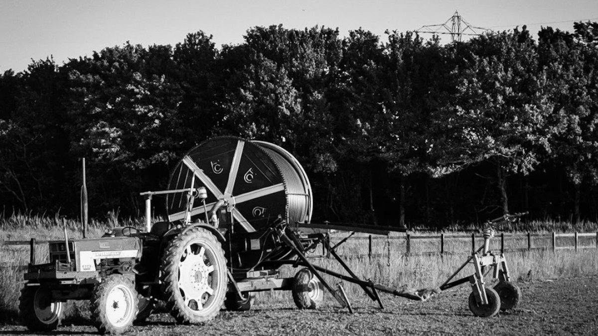 grayscale photo of tractor on field